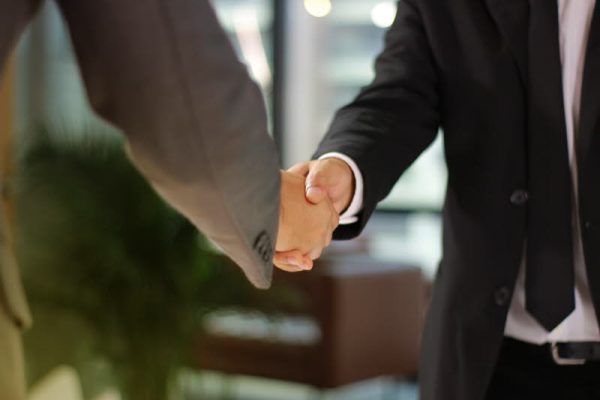 Businessmen making handshake in office business building